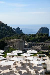 卡普里La Residenza Capri的一组白色的遮阳伞和椅子,以及海洋