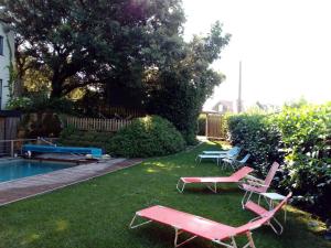 擞莫Apartamento Tipo Loft的一个带两把草坪椅和游泳池的庭院