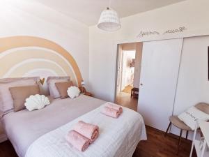 卢瓦尔河畔新堡Les Rauches - Quai Loire - Suite 2 Chambres的一间卧室配有一张大床,上面有粉红色的毛巾