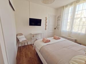 卢瓦尔河畔新堡Les Rauches - Quai Loire - Suite 2 Chambres的白色卧室配有床和椅子