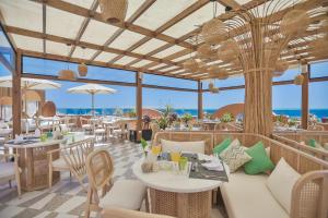 赫尔格达The Boutique Hotel Hurghada Marina的餐厅设有桌椅,背景为大海