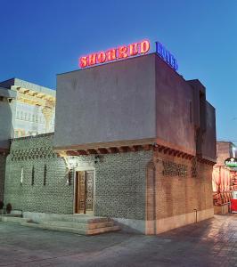 布哈拉Hotel SHOHRUD的砖砌的建筑,上面有标志