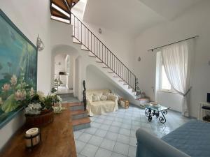 卡普里Regina di Capri - Sopramonte -的一间带楼梯和沙发的客厅
