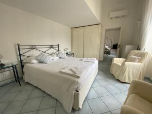 卡普里Regina di Capri - Sopramonte -的卧室配有一张白色大床和一把椅子