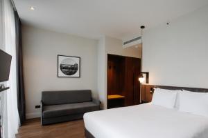 泰拉维Holiday Inn Telavi, an IHG Hotel的配有一张床和一把椅子的酒店客房