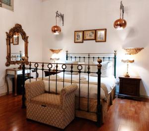 科斯皮夸Casa Birmula Boutique Hotel的一间卧室配有一张床、一把椅子和镜子