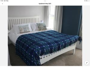 克里基厄斯Beachside holiday house的一间卧室配有一张带蓝色和白色棉被的床