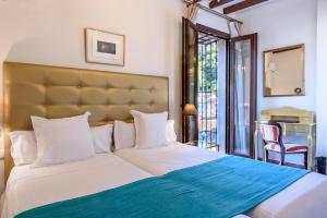 格拉纳达帕拉西奥德圣伊内斯酒店的一间卧室配有一张带蓝色毯子的大床