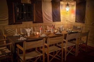 姆哈米德Desert Luxury Camp的用餐室配有桌椅和灯