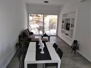 埃尔米奥尼Estia - Brand new apartment in Ermioni Village的客厅配有白色的桌子和椅子