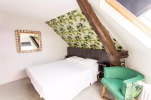 昂热耶拿酒店的一间卧室配有一张床和一把绿色椅子