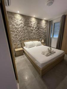 埃尔米奥尼Armonia - Brand new apartment in Ermioni Village的一间卧室设有一张床和石墙