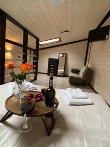 维诺吉拉季夫Chorna Skelya Resort & Wellness的一间设有一张桌子和一瓶葡萄酒的客房