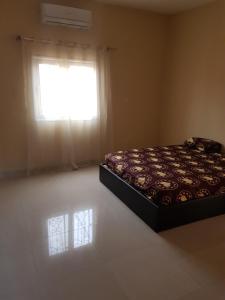 巴马科Appartement Meuble AU GOLF Bamako的卧室在窗户前配有一张床