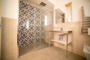 曼德洛德拉廖Locanda Alberti的带淋浴、盥洗盆和镜子的浴室