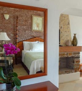 费拉希腊乐培迪酒店的配有一张床和壁炉的镜子