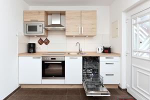 卡罗利嫩西尔Pension Pradler Wohnung 1的厨房配有白色橱柜和洗碗机。