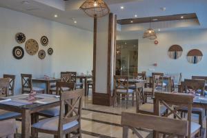 赫尔格达The Bay Hotel Hurghada Marina的一间在房间内配有桌椅的餐厅