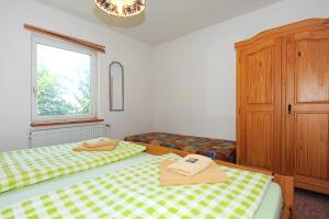 卡罗利嫩西尔Pension Pradler Wohnung 1的一间卧室设有两张床和窗户。