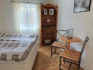 FuglstadAline's Stue, B&B Utskarpen的卧室配有1张床和1张桌子及椅子