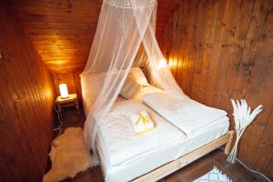 斯玛杰克托莱塞Beautiful Wooden House with Jacuzzi - Chalet Hisa Karlovsek的一间卧室配有一张带蚊帐的床