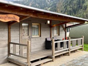 波斯基亚沃Bungalow Li Presi in Camping Cavresc, Via dal Cavresc 1, 7746 Le Prese-Poschiavo的一个小房子,设有门廊和甲板