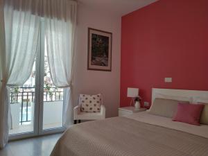 孔韦尔萨诺Dimora Francesca的卧室设有红色的墙壁、一张床和窗户