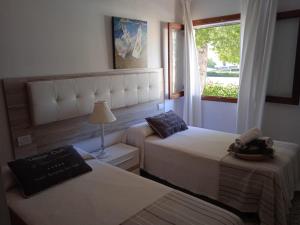 阿尔库迪亚港Apt playa de Muro ca n Ines - 1ª linea de playa的酒店客房设有两张床和窗户。
