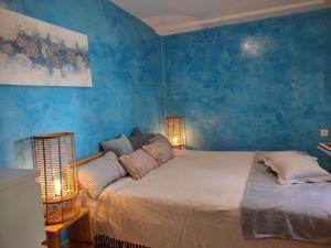 耶尔萨Stone Villa Hvar Ana and Nikola Beachfront的一间卧室配有一张带蓝色墙壁的大床
