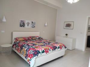 卡塔尼亚Zenzero e Limone的白色卧室配有带彩色床罩的床