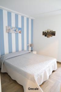 伊索拉戴里费米尼Casa Piano Ponente的一间卧室配有一张蓝色和白色条纹的床