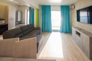 马马亚Lake Boutique Apartments & Rooms的带沙发和蓝色窗帘的客厅