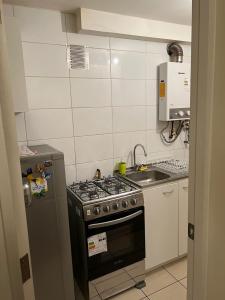 奇廉Apart Hotel Chillan - Home Cozy - Empresas - Factura - Aire acondicionado的小厨房配有炉灶和水槽