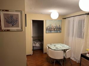奇廉Apart Hotel Chillan - Home Cozy - Empresas - Factura - Aire acondicionado的一间带桌椅的用餐室和一间卧室