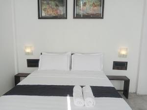 丹不拉Ridge Boundary View的卧室配有白色的床和2条毛巾