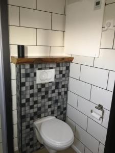 PoortvlietGlamping aan de Thoolse kust的浴室设有白色卫生间和黑白瓷砖。