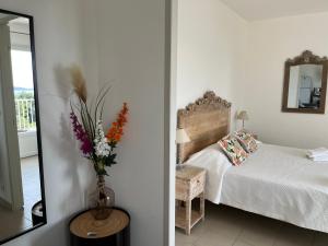 卡尔热斯盖思徒尼亚公寓的一间卧室,配有一张床和花瓶
