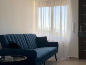 纳夫普利翁ενtreé guest house near Palamidi Castle的客厅设有蓝色沙发,配有窗户