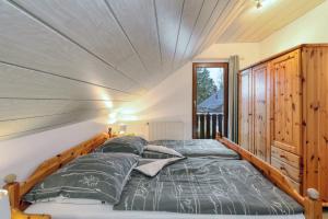 基希海姆Seepark Kirchheim Ferienhaus bei Diane mit Sauna的房屋内一间卧室,配有一张大床