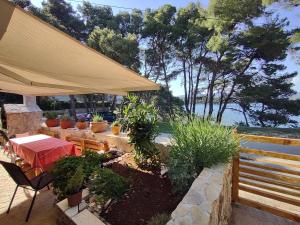 耶尔萨Stone Villa Hvar Ana and Nikola Beachfront的庭院配有桌椅和树木
