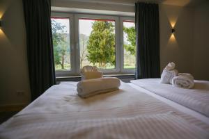 特拉本特拉巴赫Rieslingresidenz的卧室配有带窗户的床上的2条白色毛巾