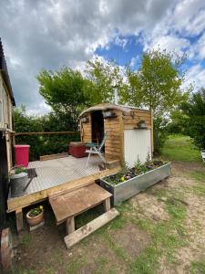 MellisMr Hares shepherd hut的木甲板上设有长凳和房子