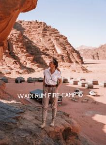 瓦迪拉姆Wadi Rum Fire Camp的站在沙漠岩石上的女人