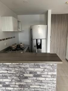 佩雷拉Apartasuite 01的厨房配有砖台面和冰箱