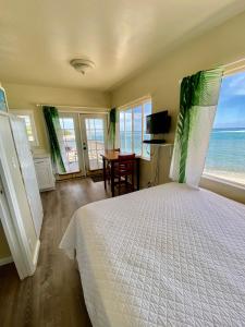 WaialuaMokulē'ia Beach Houses at Owen's Retreat的一间卧室设有一张床,享有海景
