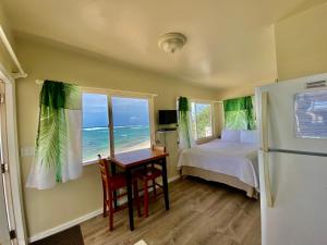 WaialuaMokulē'ia Beach Houses at Owen's Retreat的一间卧室配有一张床、一张书桌和一个窗户。