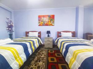 利马Samay Wasi - Aeropuerto的一间卧室设有两张床,墙上挂着一幅画