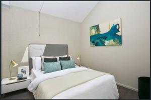 伯恩特隆斯代尔Lonnie Beach View Apartment的卧室配有一张床,墙上挂有绘画作品
