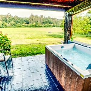 TroitosendeA Carballeira do Tambre的庭院内的热水浴池,享有田野美景