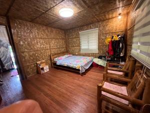 锡朗Bahay Kubo ZaiLaiH的一间小房间,配有一张床和木地板